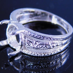 May include: Silver ring setting with a decorative filigree design and a prong setting for a large oval stone.