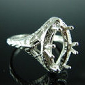 May include: Silver ring setting with an oval-shaped center stone. The setting has a delicate filigree design and six prongs to hold the stone in place.