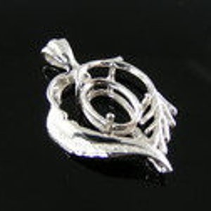 May include: Silver pendant setting with a heart-shaped design featuring two wings. The setting is designed to hold a large oval-shaped gemstone.