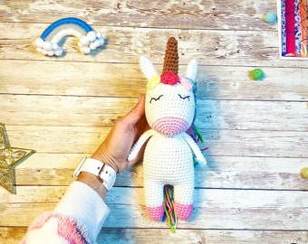 Crochet white baby unicorn with a rainbow braid and tail