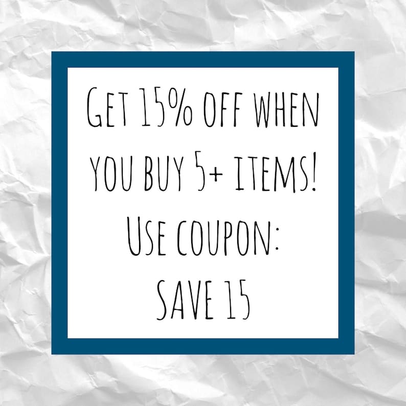 May include: A white rectangular sign with a dark blue border displays the text "GET 15% OFF WHEN YOU BUY 5+ ITEMS! USE COUPON: SAVE 15" in black handwritten font. The background is a crumpled white paper texture.