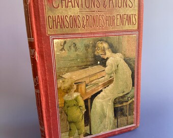 May include: A red book with gold lettering titled "Chantons & Rions! Chansons & Rondes Pour Enfants" with an illustration of a woman playing a piano and a child watching.
