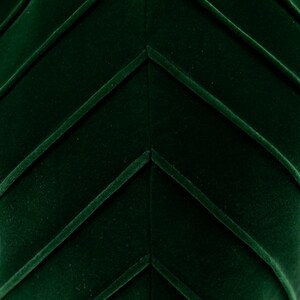 Op de afbeelding: Close-up van een donkergroene stof met een chevron-patroon. De stof heeft een zachte, fluweelachtige textuur.