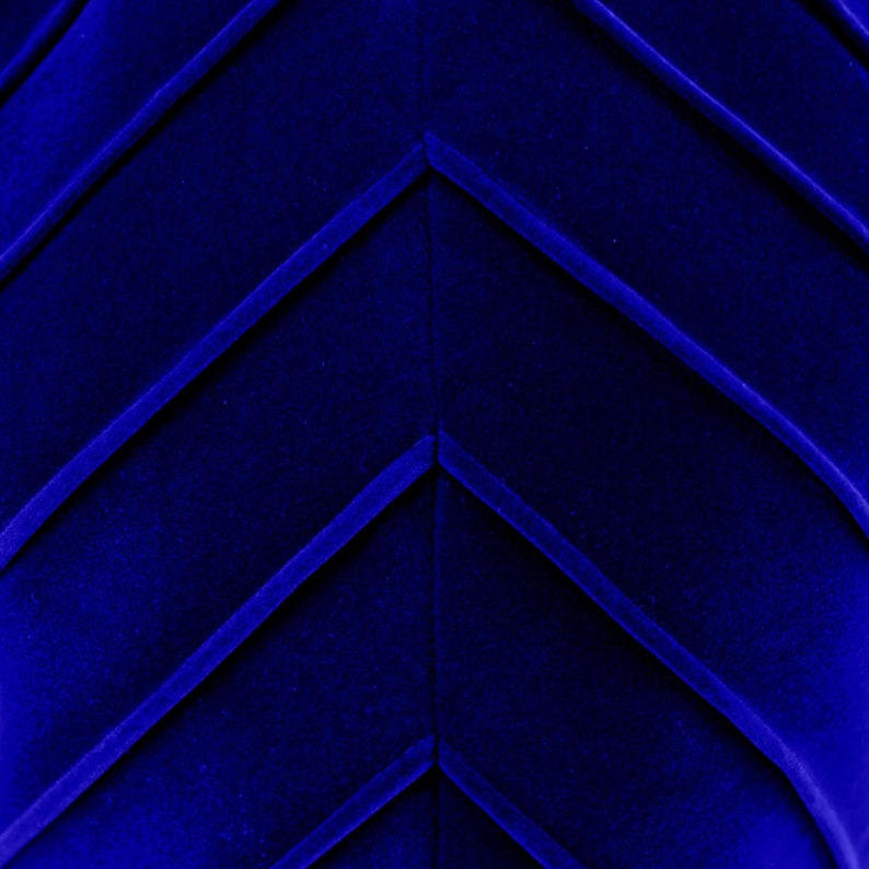 Op de afbeelding: Close-up van een diepblauwe stof met een chevron-patroon. De stof heeft een zachte, fluweelachtige textuur.