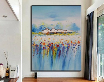 Könnte beinhalten: Ein originales Ölgemälde auf Leinwand, das eine lebendige Landschaft mit einem Feld bunter Blumen im Vordergrund zeigt. Weiße Gebäude stehen vor einem blauen Himmel mit Vögeln. Das Kunstwerk ist in einem schwarzen Rahmen eingefasst.