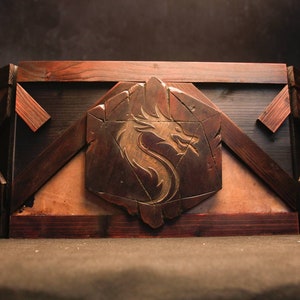 May include: A wooden box with a geometric design and a carved dragon on the front. The box is made of dark wood with a light brown interior.