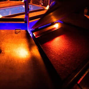 May include: A wooden box with a red velvet interior. The box is open and the velvet is illuminated by a warm light.