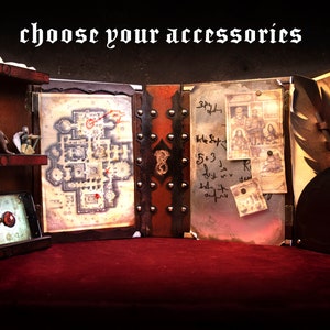 May include: A tabletop display featuring a map, figurines, and a smartphone displaying a chess piece. The display is made of wood and leather, with the text "CHOOSE YOUR ACCESSORIES" at the top. The overall theme is fantasy role-playing.