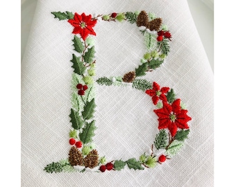 May include: Embroidered Christmas letter B with a wreath of holly, pine branches, red berries, and poinsettia flowers.