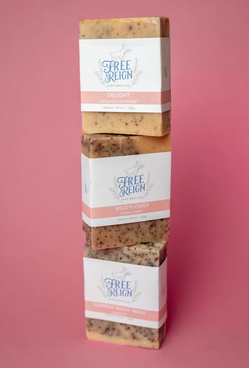 May include: Three bars of goat milk soap stacked on top of each other. The top bar is labeled "Delight Lavender & Spearmint", the middle bar is labeled "Wild Flower Floral & Mint", and the bottom bar is labeled "Summer Night Walk".