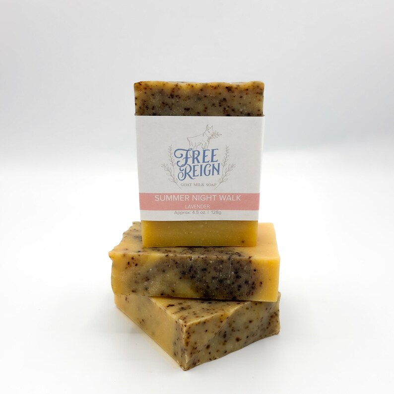 May include: Three bars of goat milk soap stacked on top of each other. The top bar has a label that reads "Free Reign Goat Milk Soap Summer Night Walk Lavender Approx. 4.5 oz | 130g".
