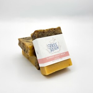 May include: Two bars of goat milk soap stacked on top of each other. The top bar is labeled "Free Reign Goat Milk Soap Summer Night Walk Lavender Approx: 4.5 oz. 1.12oz".