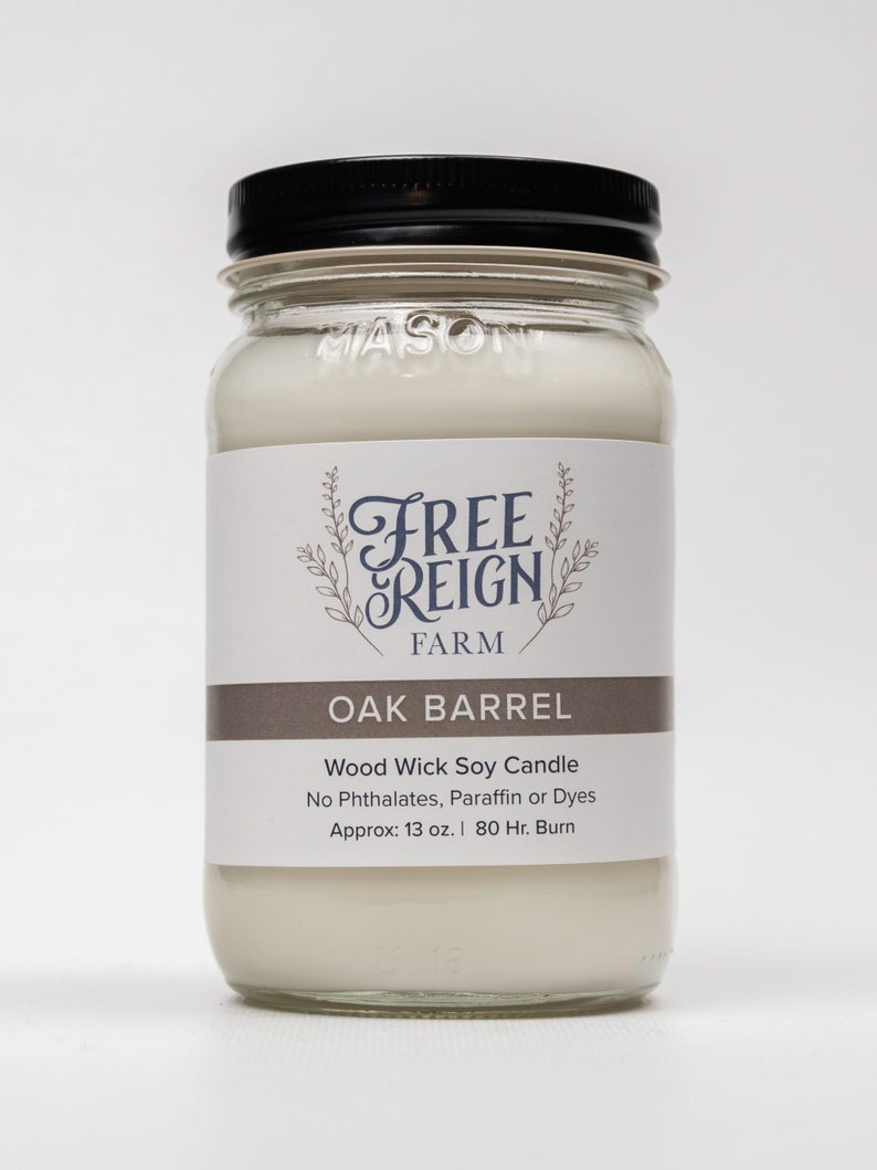 Pu&ograve; includere: Una candela di soia bianca in un barattolo di vetro trasparente con un coperchio nero. L'etichetta riporta "Free Reign Farm" e "Oak Barrel". La candela &egrave; una candela di soia con stoppino in legno senza ftalati, paraffina o coloranti. Ha un peso di circa 13 once e una durata di 80 ore.