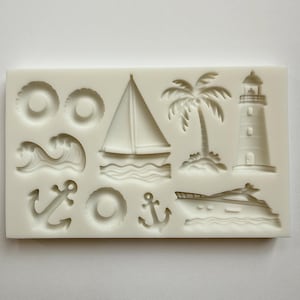 May include: A white silicone mold featuring nautical-themed shapes. Designs include a sailboat, lighthouse, palm tree, anchors, life preservers, waves, and a yacht. The mold is designed for creating decorative elements.