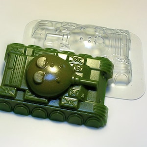 May include: A green plastic toy tank mould with a clear plastic mould on top. The tank mould has a round turret and tracks.