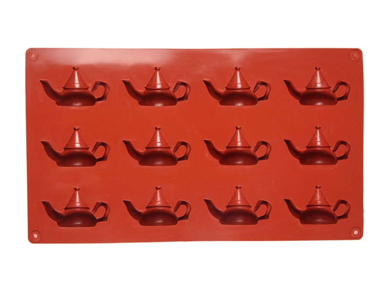 May include: A red silicone mold with 12 teapot-shaped cavities. The mold is designed for making small, decorative teapots.