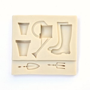 May include: A silicone mold for making small garden-themed decorations. The mold features a watering can, two flower pots, a pair of boots, a trowel, and a garden fork.
