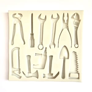 May include: A silicone mould with 12 different tool shapes, including a wrench, hammer, screwdriver, saw, and pliers. The mould is designed for making edible decorations for cakes or other desserts.