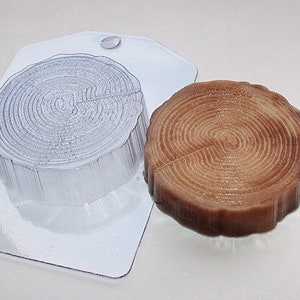 May include: A clear plastic mold shaped like a tree stump with a brown resin cast of a tree stump.