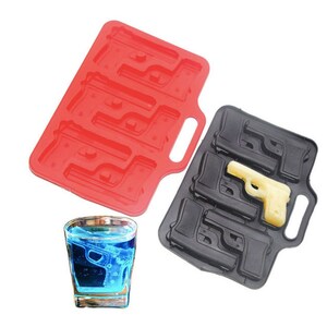 May include: Two silicone ice cube trays shaped like handguns, one red and one black. A glass of blue liquid with a handgun-shaped ice cube is also shown. The trays have handles for easy removal of the ice cubes.