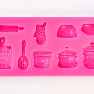 May include: A bright pink silicone baking mold featuring various kitchen-themed shapes. Includes a rolling pin, oven mitt, bowls, a cutting board with "Baked with Love" text, a spoon, a jar, and a flour container.