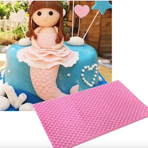 May include: Pink silicone cake decorating mat with a diamond pattern. The mat is used to create textured designs on fondant or gum paste.