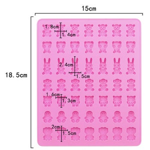 Pode incluir: Forma de silicone rosa com 24 cavidades para fazer doces ou chocolate. A forma apresenta diferentes formas de animais, incluindo ursos, coelhos, corujas e pinguins. A forma mede 18,5 cm por 15 cm.