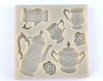 May include: Silicone mold for making cake decorations. The mold features a teapot, sugar bowl, creamer, and two cups, all with a floral design.