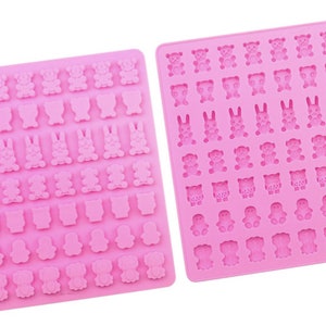Pode incluir: Dois moldes de silicone rosa para fazer doces ou chocolate. Os moldes apresentam diferentes formas de animais, incluindo ursos, coelhos, corujas, pinguins e gatos.