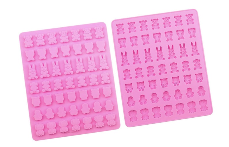 Pode incluir: Dois moldes de silicone rosa para fazer doces ou chocolate. Os moldes apresentam diferentes formas de animais, incluindo ursos, coelhos, corujas, pinguins e gatos.