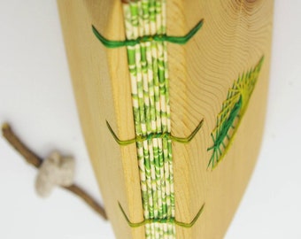 May include: A wooden journal with a green and white patterned spine, bound with green string. The cover is made of natural wood with a green embroidered design.