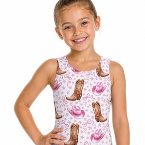 May include: A sleeveless one-piece swimsuit featuring a white background with a repeating pattern of brown cowboy boots, pink cowboy hats, and small pink stars and ribbons. The garment has a round neckline and a classic cut leg opening.