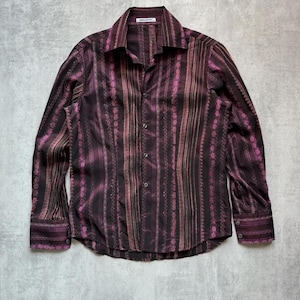 May include: A long-sleeved button-down shirt with a striped pattern in shades of purple and brown. The shirt has a collar and a button-up front.