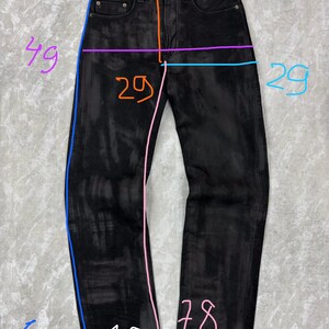 May include: Black denim jeans featuring a button fly, five-pocket styling, and a faded wash. The garment is annotated with coloured lines and numbers indicating measurements in centimetres, including a waist of 37 cm, length of 106 cm, and inseam of 78 cm.