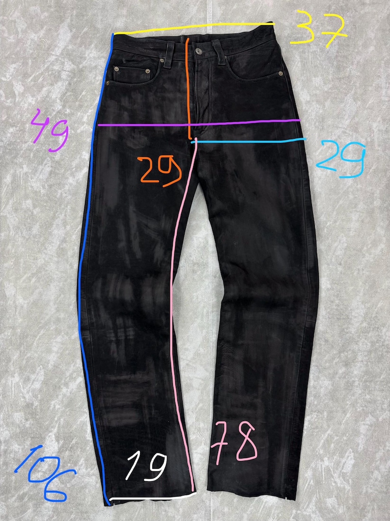 May include: Black denim jeans featuring a button fly, five-pocket styling, and a faded wash. The garment is annotated with coloured lines and numbers indicating measurements in centimetres, including a waist of 37 cm, length of 106 cm, and inseam of 78 cm.