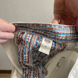 May include: White denim jeans with a patterned inner lining. The label reads "EDWIN 4545 SIZE 32 EXV-2130 E634-2310".