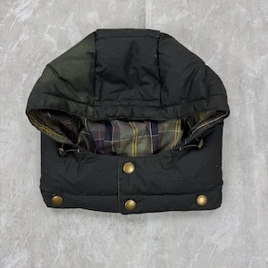 Può includere: Cappuccio nero per giacca con design trapuntato e tre bottoni color oro. L'interno presenta un motivo a quadri nei toni del verde, rosso e giallo. Il cappuccio è progettato per essere attaccato a una giacca.