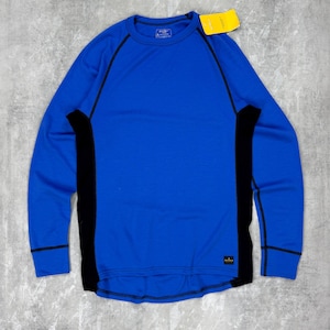 May include: A long-sleeved, crew neck shirt in a vibrant blue with black side panels and trim. A yellow tag is attached near the neckline. The shirt has a simple, athletic design.