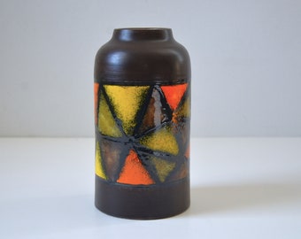 May include: A brown ceramic vase with a geometric pattern of orange, yellow, and green triangles.