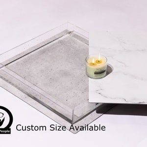 May include: A clear acrylic tray with a gray concrete base. The tray is sitting on a white marble surface. A candle is sitting on the marble surface. The text "Custom Size Available" is printed below the tray.