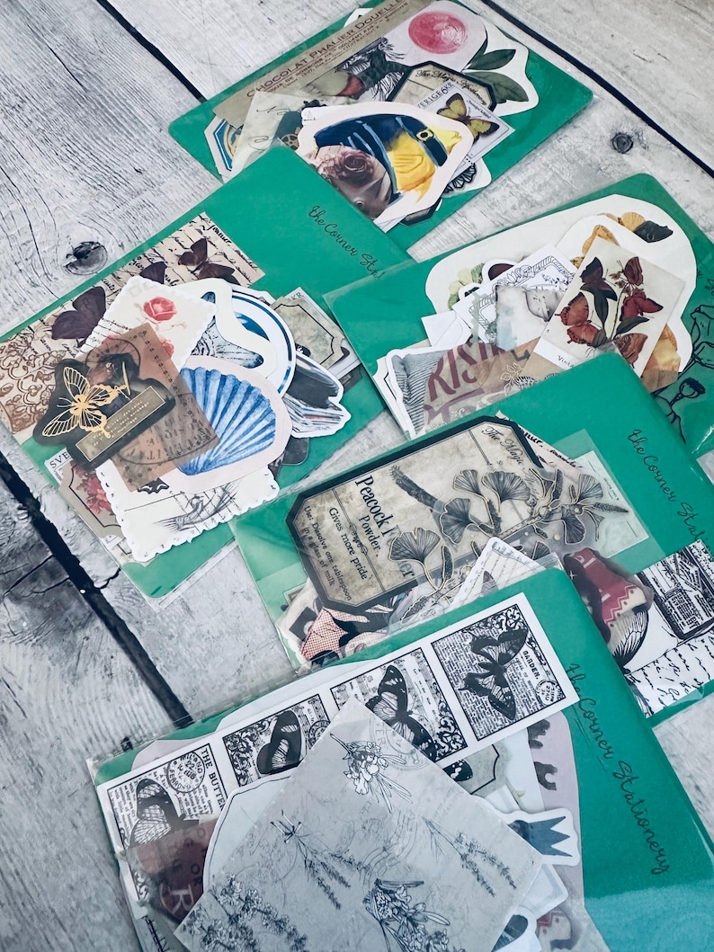 May include: A set of vintage-style stickers featuring butterflies, flowers, and other botanical designs. The stickers are packaged in clear plastic bags with green borders and the text "The Corner Stationery" printed on them.