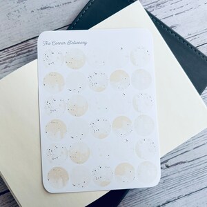 A sheet of 30 round moon like vinyl stickers for junk journaling, journaling, planner and scrapbooking.