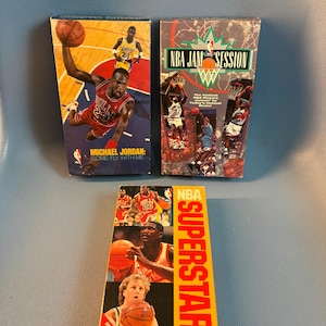 May include: A white ceramic mug with a black handle and the text "But First, Coffee" in a black, handwritten-style font. The mug is on a white surface.