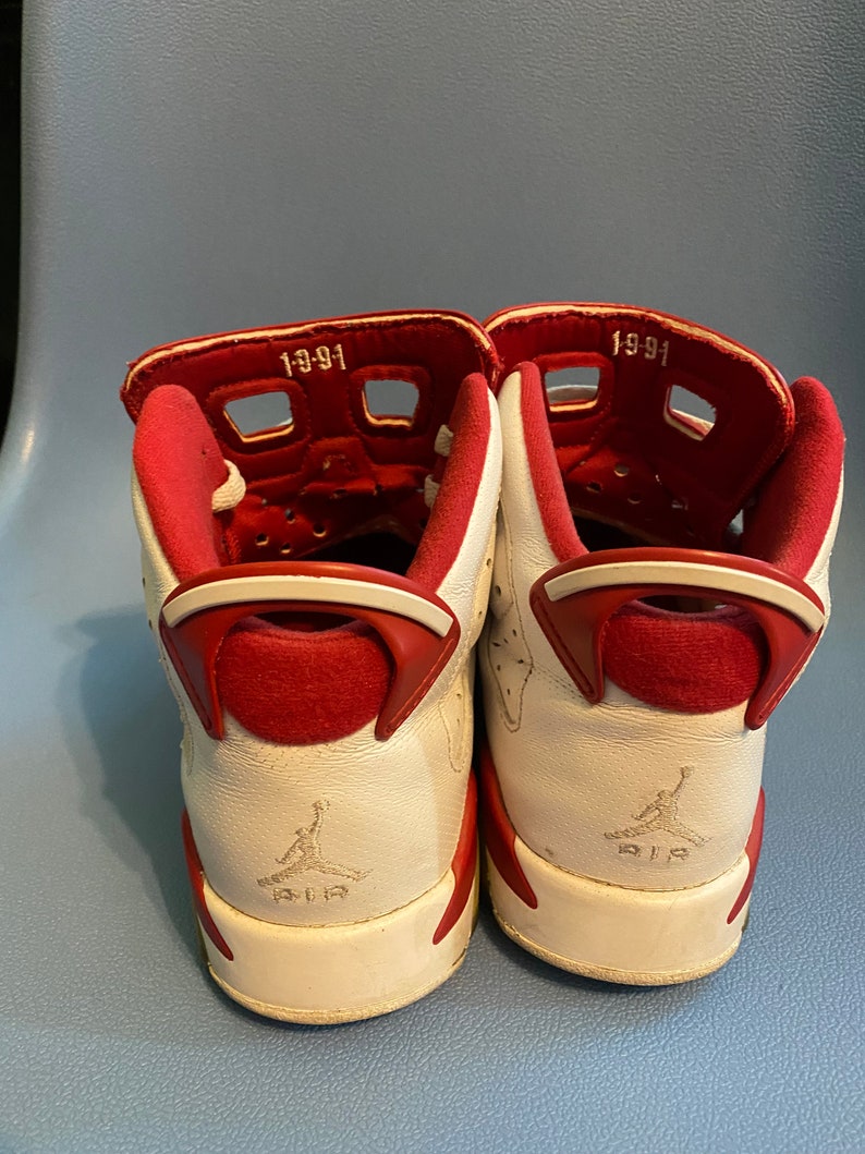 May include: A pair of white and red sneakers with the text "1991" on the back of each shoe.