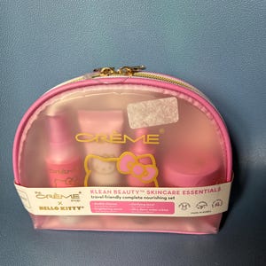 May include: A pink Hello Kitty travel-sized skincare set in a clear plastic pouch with a zipper. The set includes a cleanser, toner, and moisturizer. The pouch has the text "KLEAN BEAUTY&trade; SKINCARE ESSENTIALS" and "travel-friendly complete nourishing set".