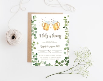 May include: A baby shower invitation with a green eucalyptus and gold glitter design. The invitation features two gold beer mugs with the text "A baby is brewing" and "Join us for a couples shower honoring Bryant & Jessica Hall".