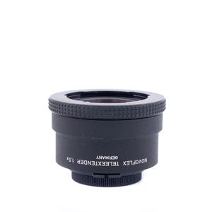 May include: A black Novoflex Teleextender 1.5x lens adapter, made in Germany. The adapter has a textured ring around the top and the text "NOVOFLEX TELEEXTENDER 1.5x GERMANY" printed on the side. The lens adapter is designed for cameras.