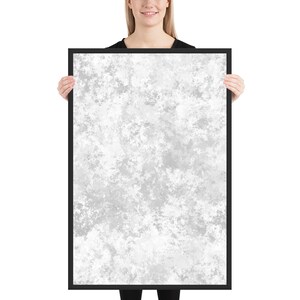 May include: A framed print with a white and gray abstract design. The design resembles a cloudy sky or a textured surface.