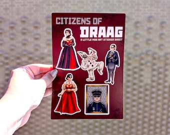 May include: A rectangular sticker sheet with a dark red background featuring the text CITIZENS OF DRAAG A LITTLE MOD ART STICKER SHEET. It includes five distinct character illustrations: two figures in red dresses, a clown, a professional in a suit, and a portrait.