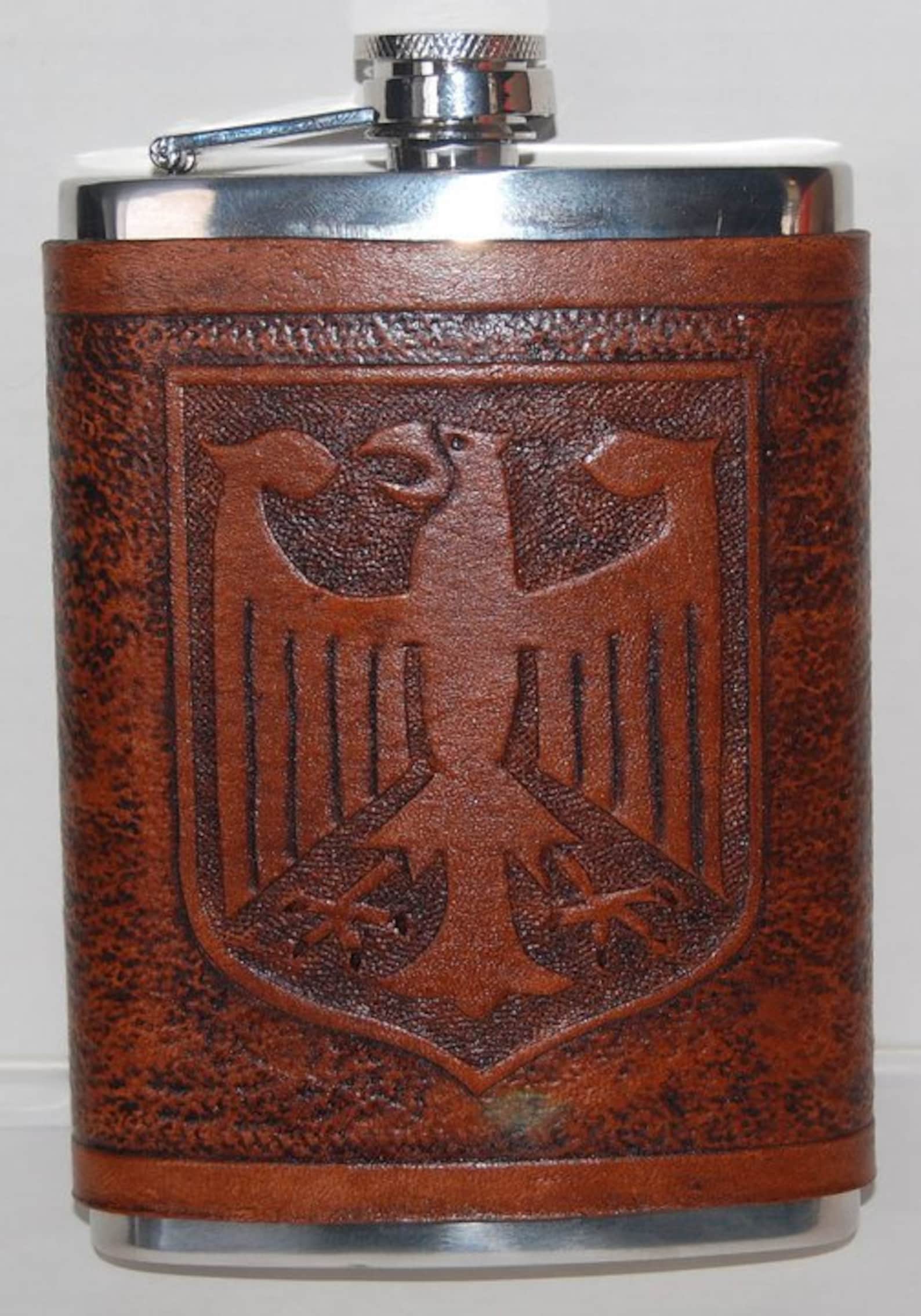 8 ounce stainless steel flask with a leather wrap that has a German Eagle carved in it